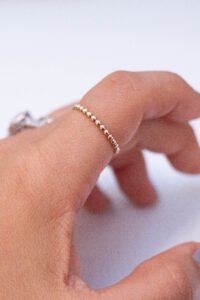 gold ball ring on finger